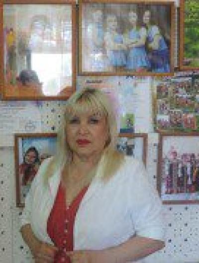 Бенеда возле стенда своих воспитанников